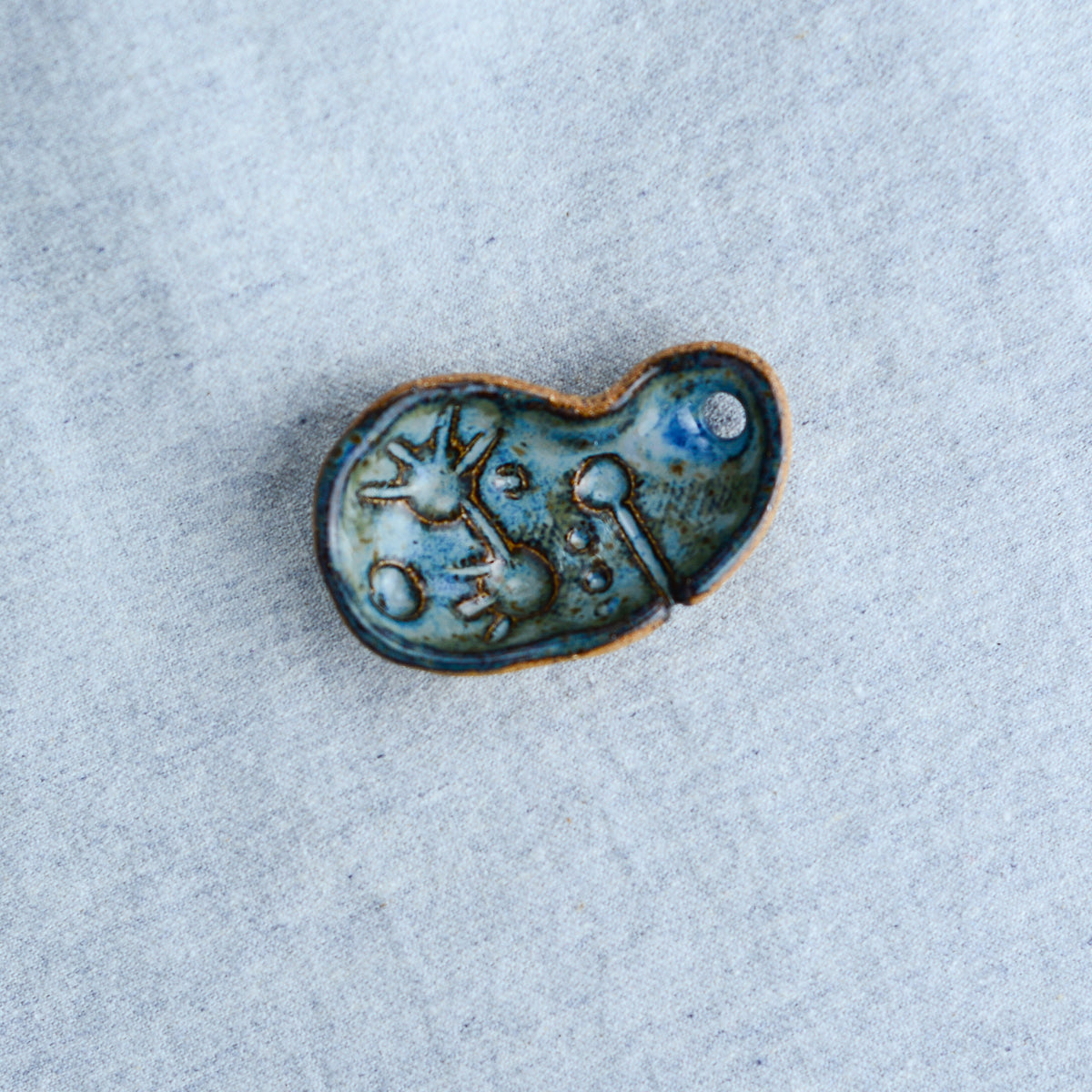 Miniature ceramic sculpture, curved for use as a handheld worry stone