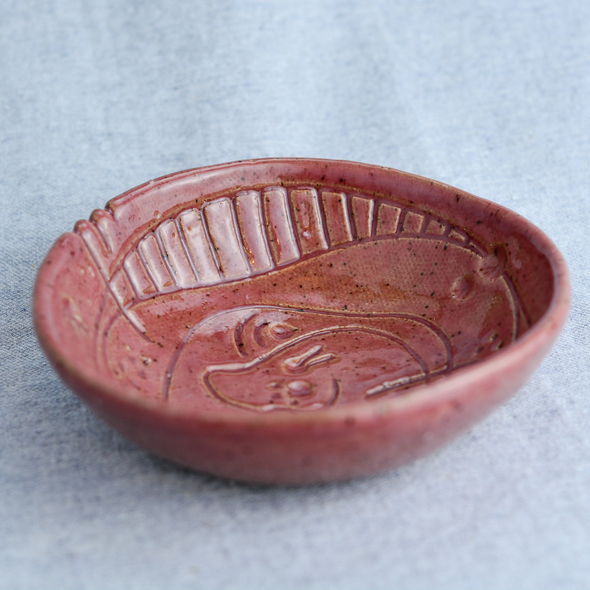 A handmade circular bowl with celestial and astrological carvings