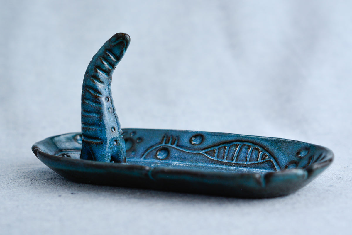 Ceramic ring tray featuring a tiny dinoasur-like creature; created with a mix of sculpture, slab work, and surface design