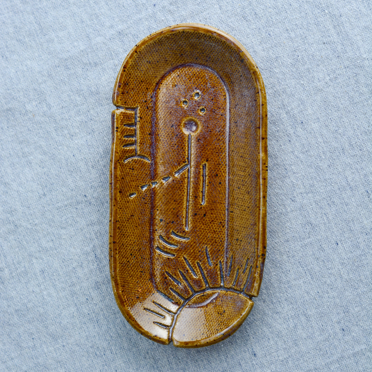 A charming oblong dish, ideal for holding rings, keys, or a splash of soy sauce. Each piece is unique, showcasing a distinctive hand-carved motif and a matching hand-painted finish.