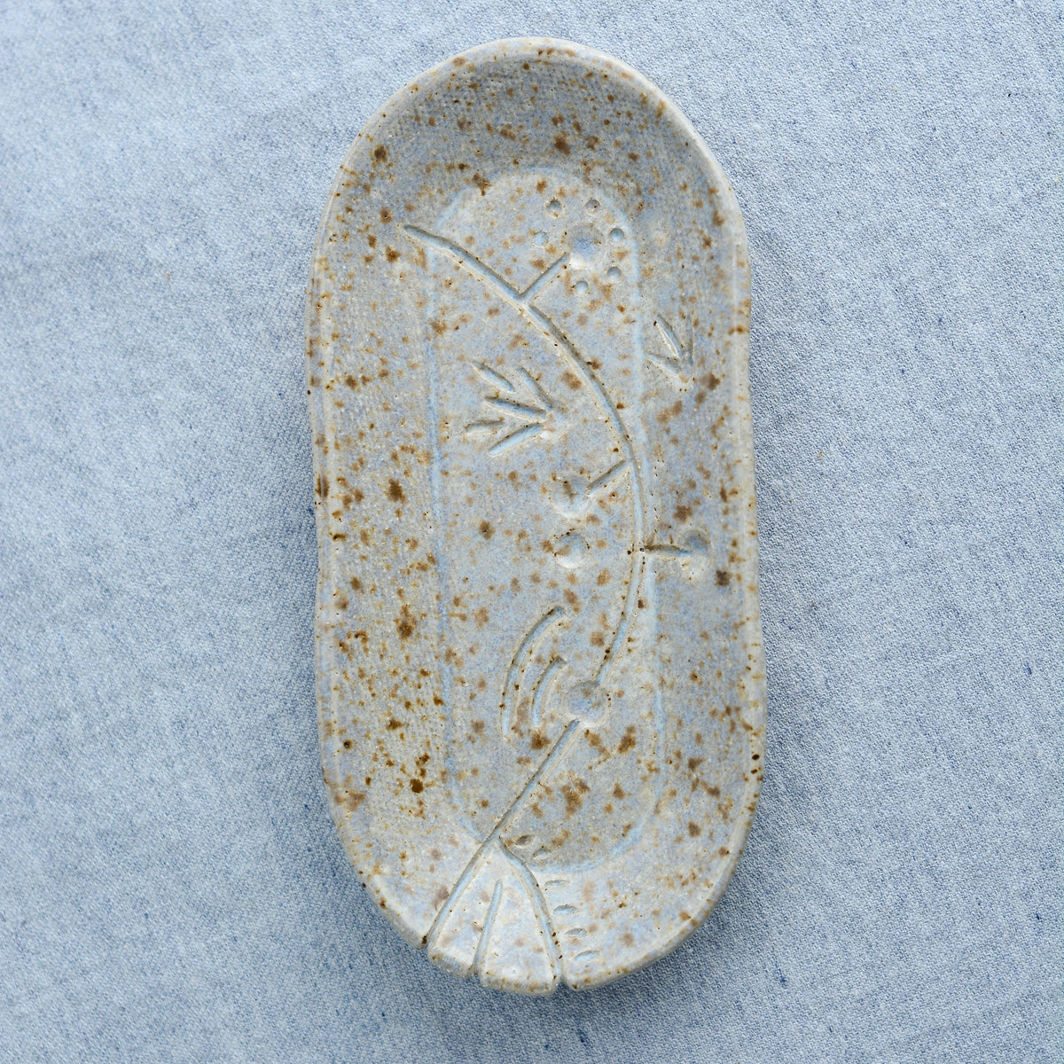 A charming oblong dish, ideal for holding rings, keys, or a splash of soy sauce. Each piece is unique, showcasing a distinctive hand-carved motif and a matching hand-painted finish.