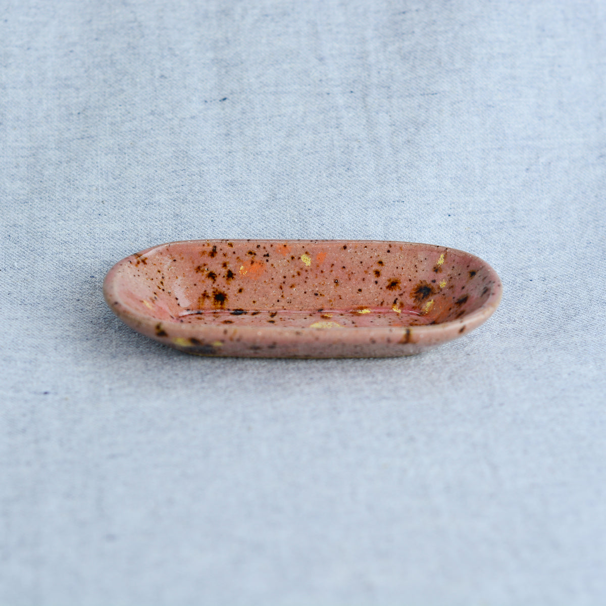 A smaller oblong dish, ideal for holding rings, keys, or a splash of soy sauce. Each piece is unique, showcasing a distinctive hand-carved motif and a matching hand-painted finish.
