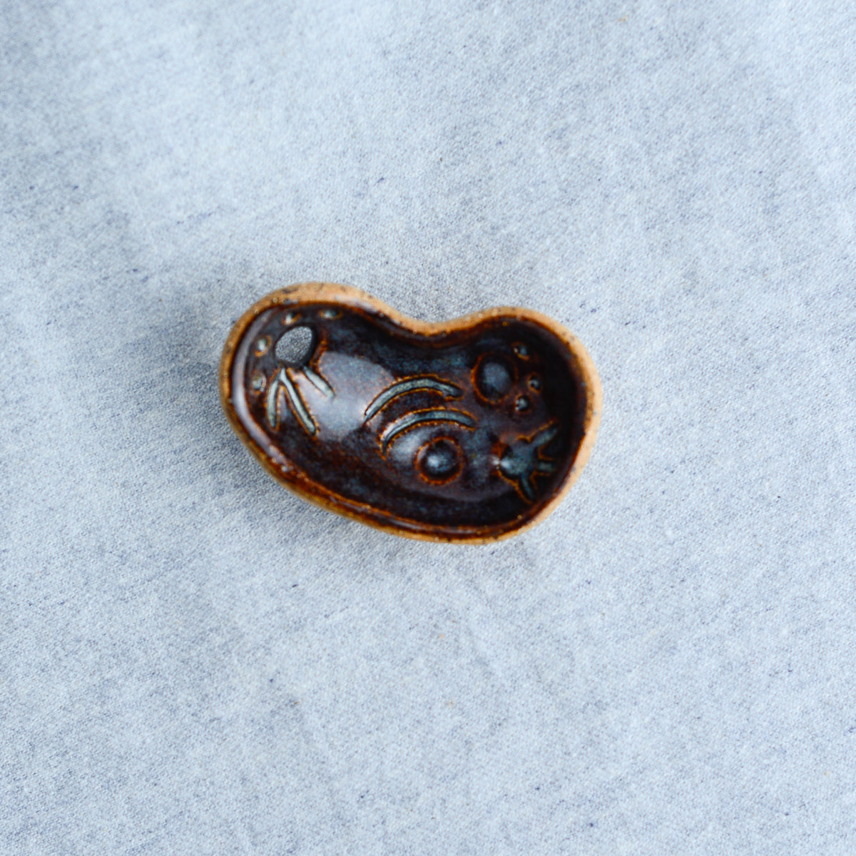 Miniature ceramic sculpture, curved for use as a handheld worry stone