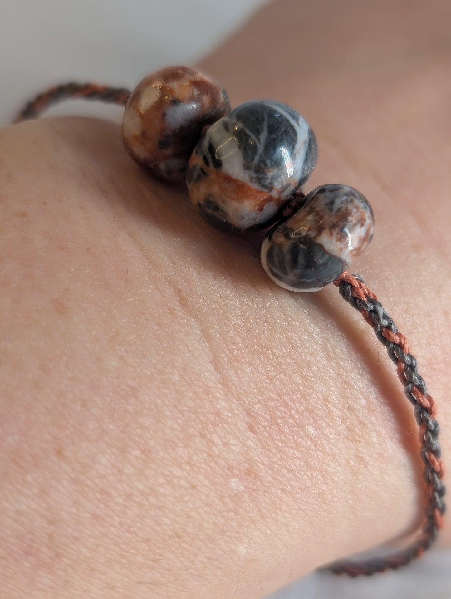 Close-up of a bracelet with stone beads on a wrist.