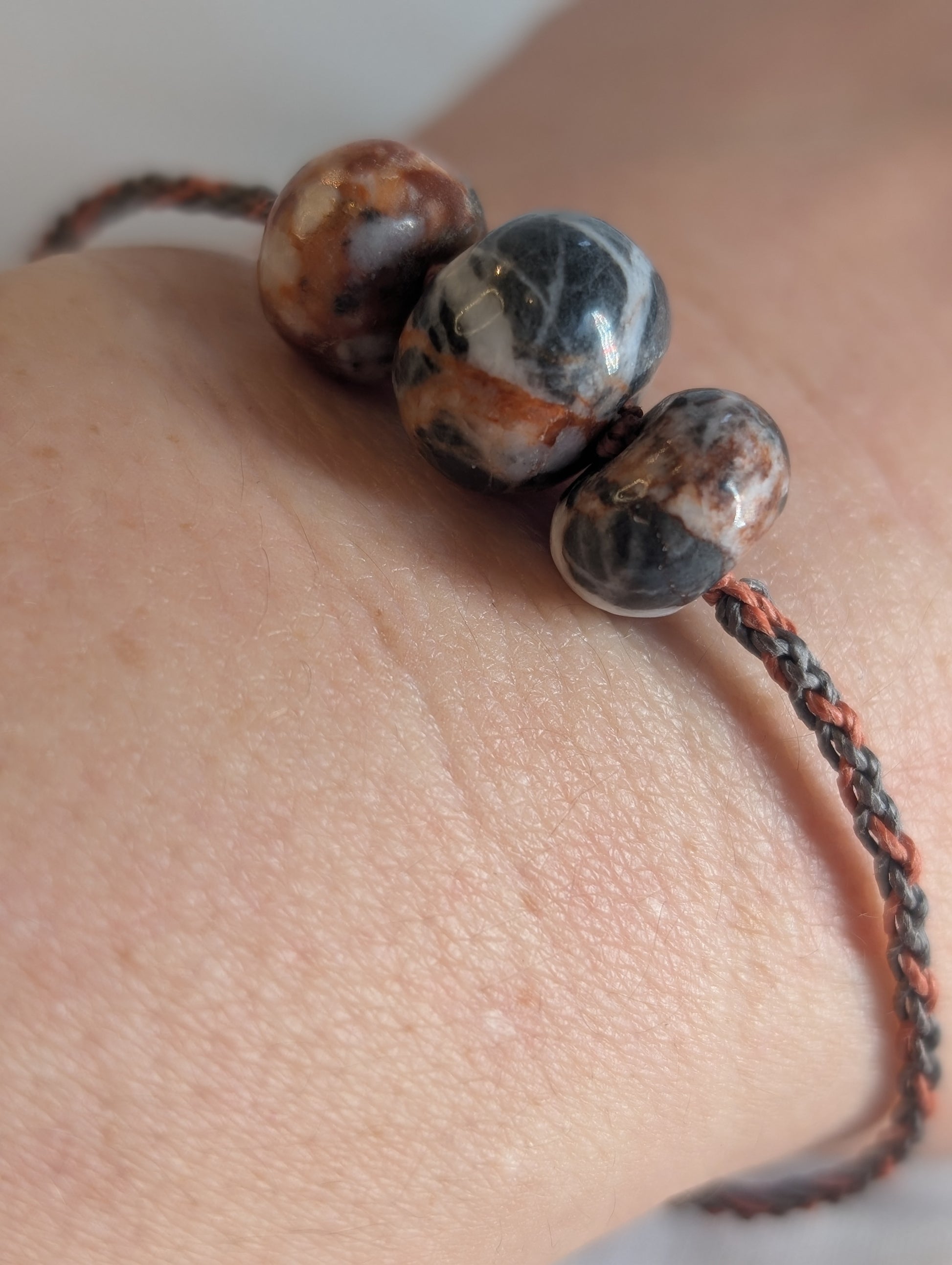 Close-up of a bracelet with stone beads on a wrist.