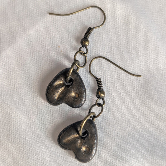 Pair of bronze ceramic heart-shaped earrings on a white background