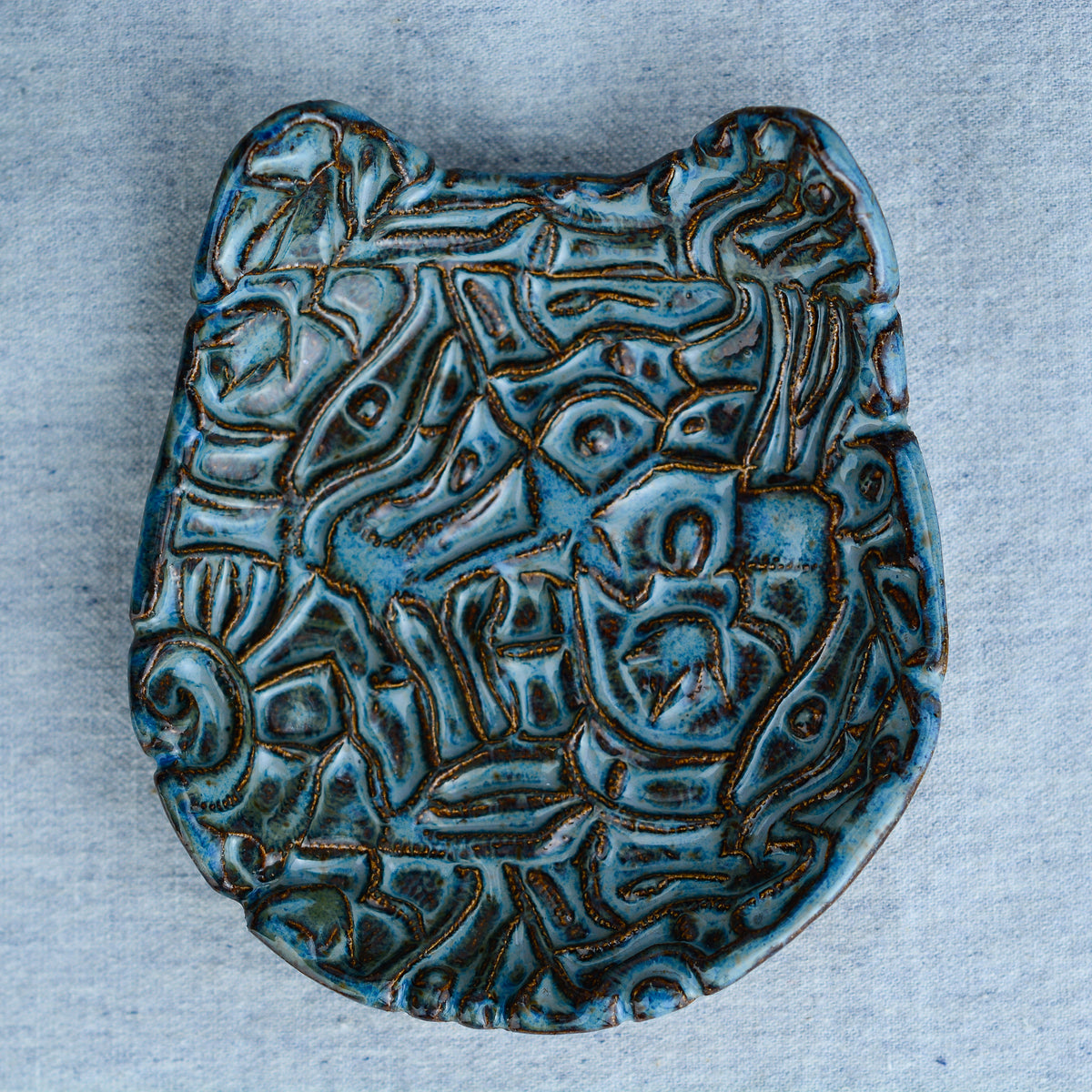 Ceramic cat-shaped dish with an intricate, organic, hand-carved abstract pattern