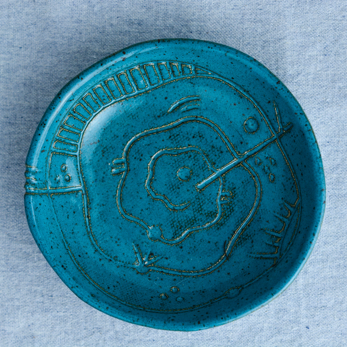 A handmade circular bowl with celestial and astrological carvings