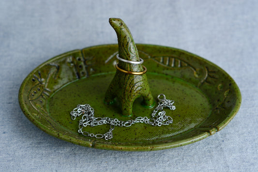 Ceramic ring tray featuring a tiny dinoasur-like creature; created with a mix of sculpture, slab work, and surface design