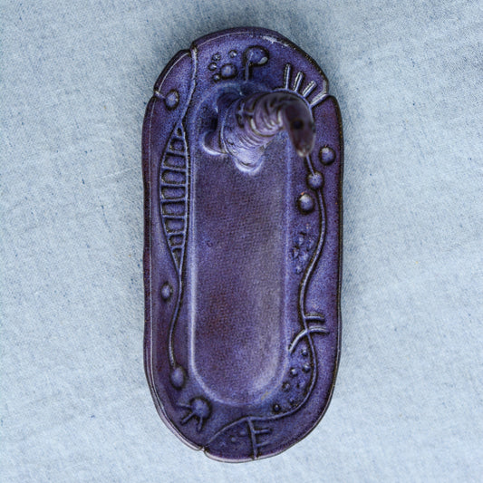 Ceramic ring tray featuring a tiny dinoasur-like creature; created with a mix of sculpture, slab work, and surface design