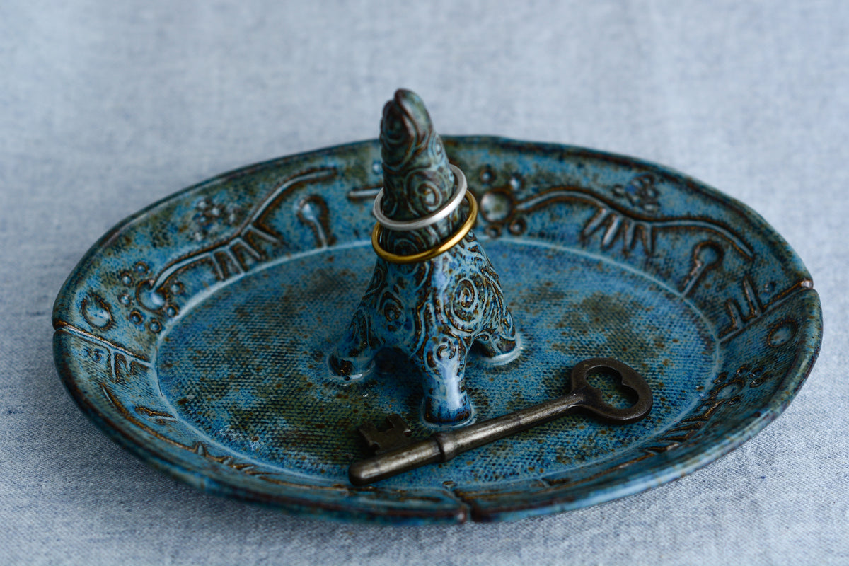 Ceramic ring tray featuring a tiny dinoasur-like creature; created with a mix of sculpture, slab work, and surface design