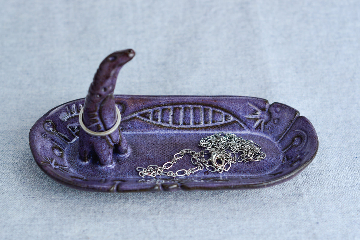 Ceramic ring tray featuring a tiny dinoasur-like creature; created with a mix of sculpture, slab work, and surface design
