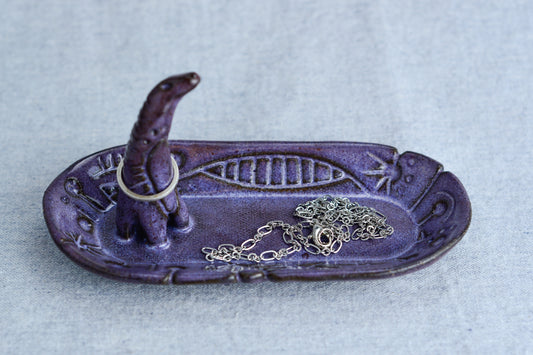 Ceramic ring tray featuring a tiny dinoasur-like creature; created with a mix of sculpture, slab work, and surface design