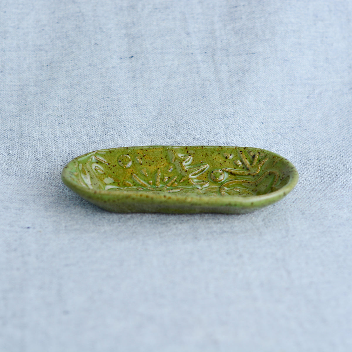 A smaller oblong dish, ideal for holding rings, keys, or a splash of soy sauce. Each piece is unique, showcasing a distinctive hand-carved motif and a matching hand-painted finish.