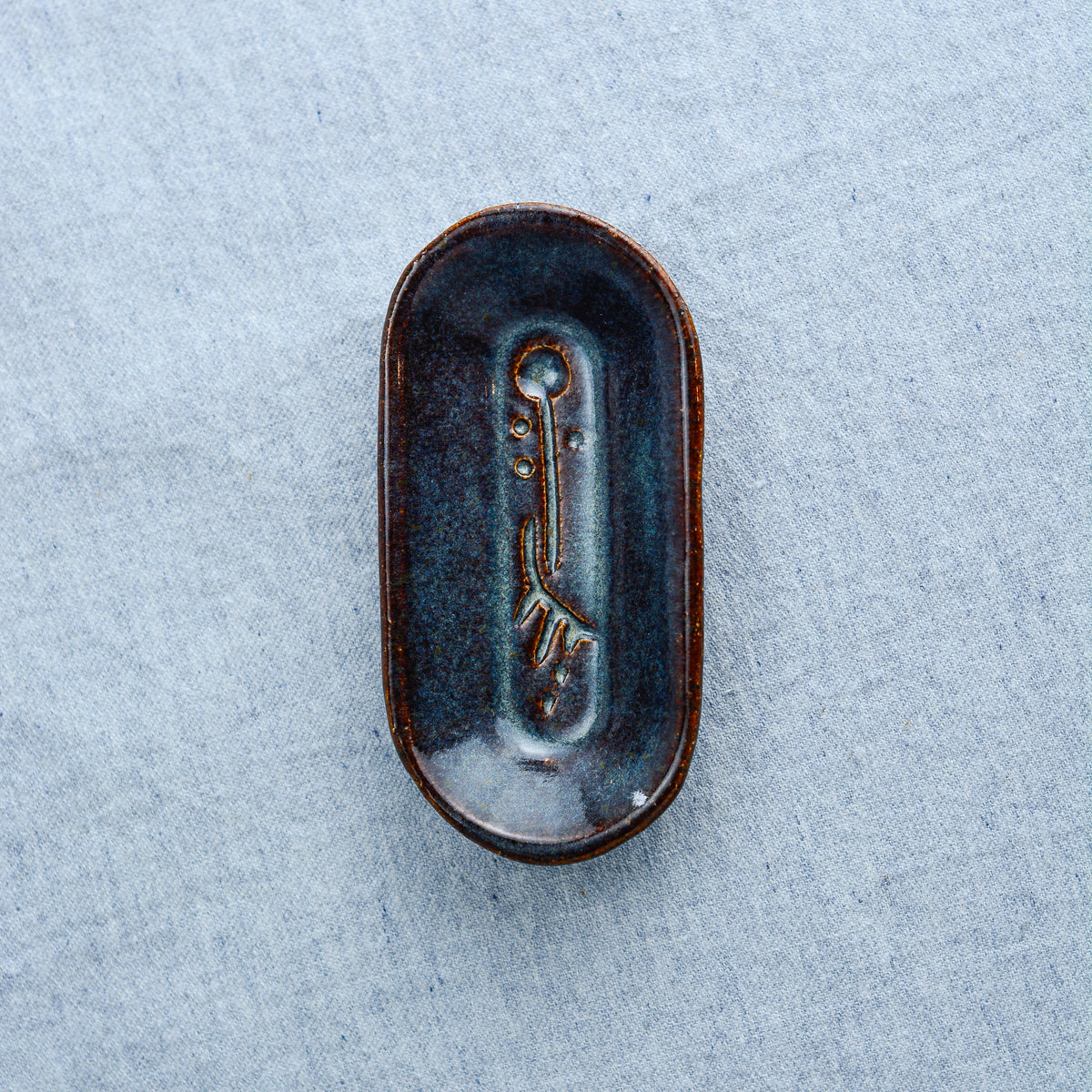 A smaller oblong dish, ideal for holding rings, keys, or a splash of soy sauce. Each piece is unique, showcasing a distinctive hand-carved motif and a matching hand-painted finish.
