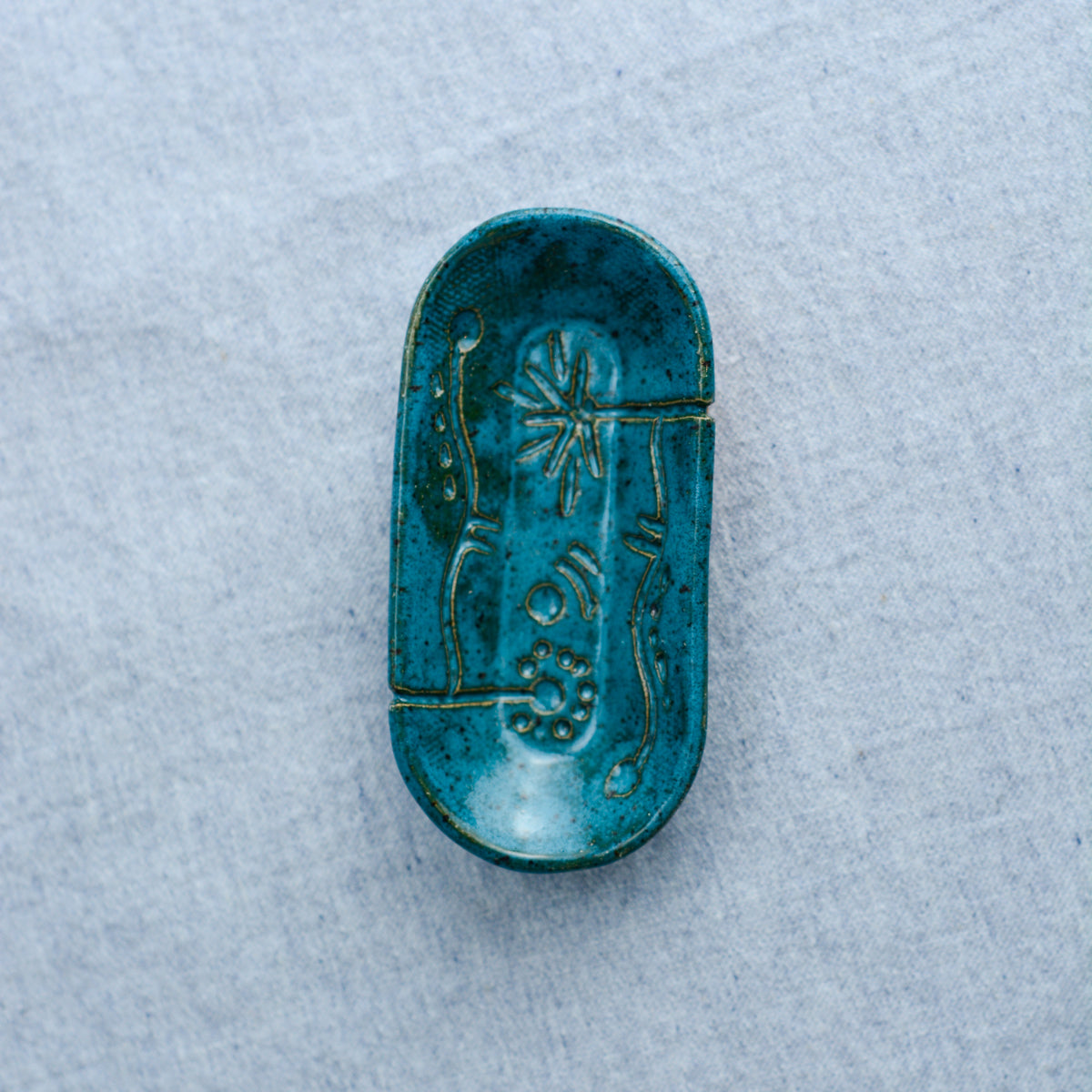A smaller oblong dish, ideal for holding rings, keys, or a splash of soy sauce. Each piece is unique, showcasing a distinctive hand-carved motif and a matching hand-painted finish.