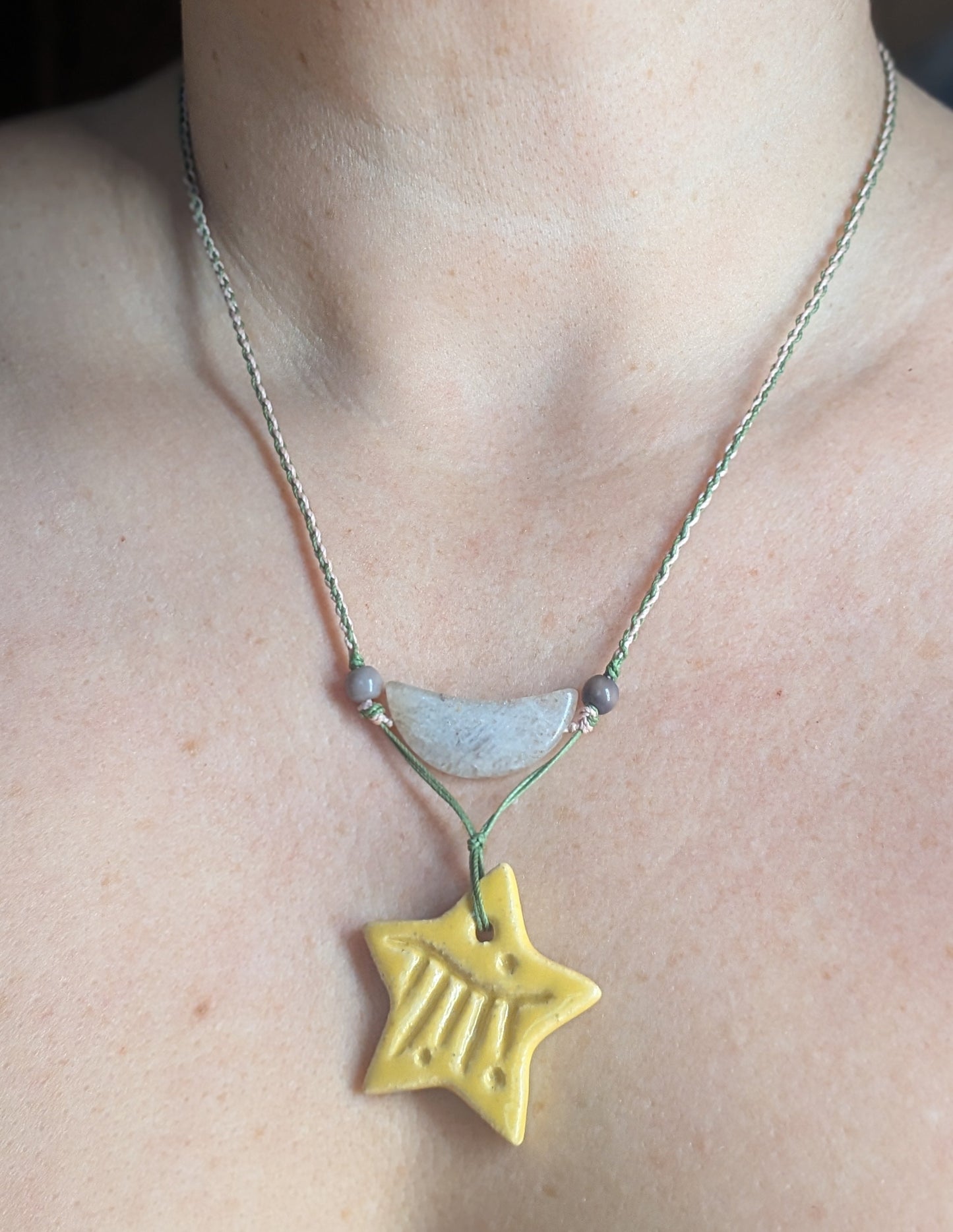 Necklace with a yellow star pendant worn by a person