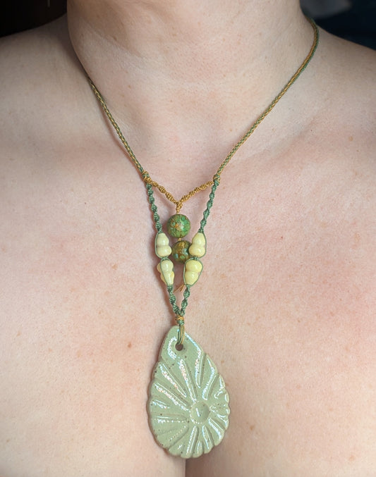 Necklace with a green pendant worn by a person