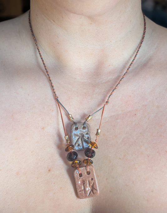 Necklace with a pendant worn by a person, with a blurred background