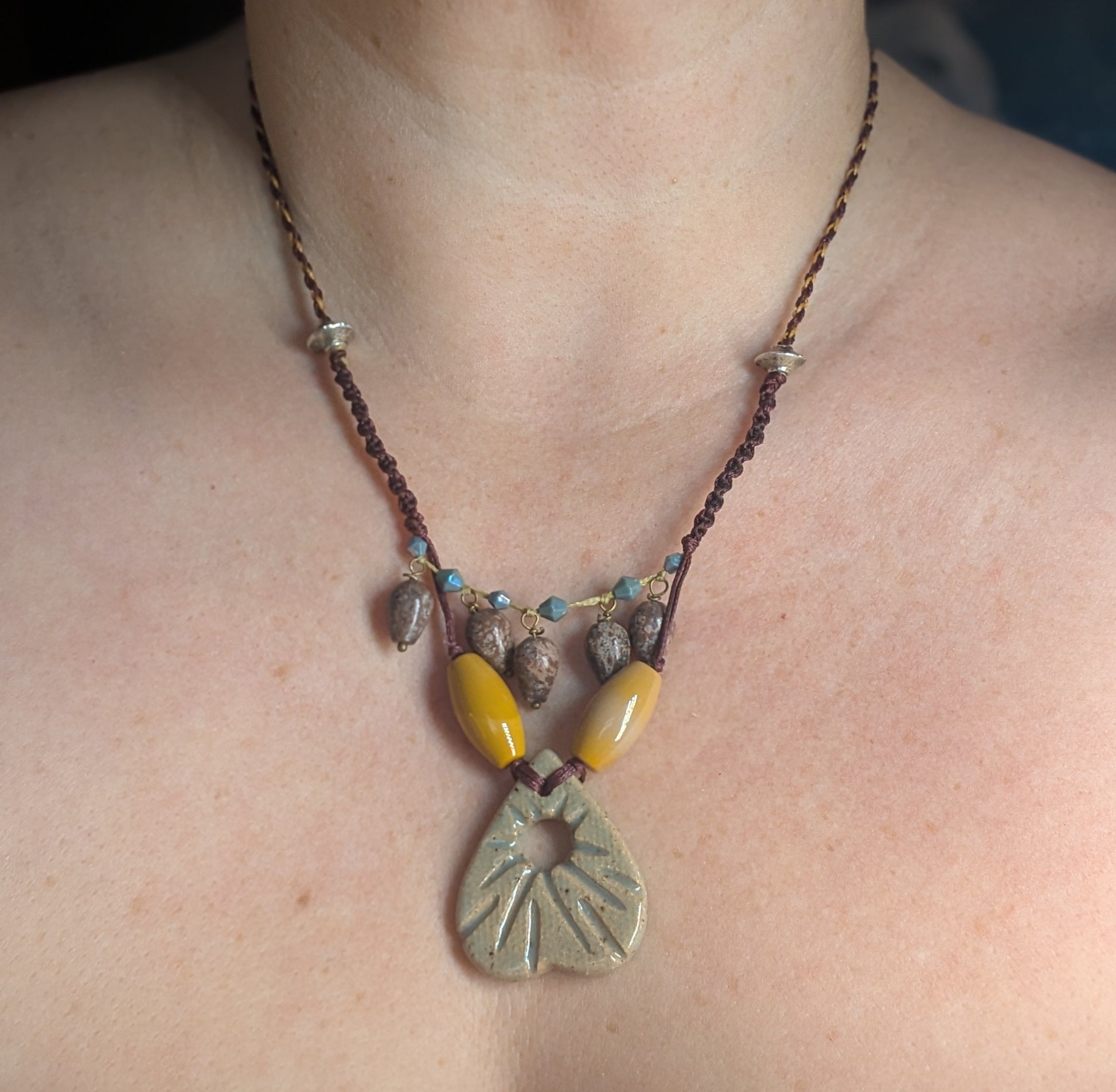 Necklace with a pendant worn by a person, close-up view.