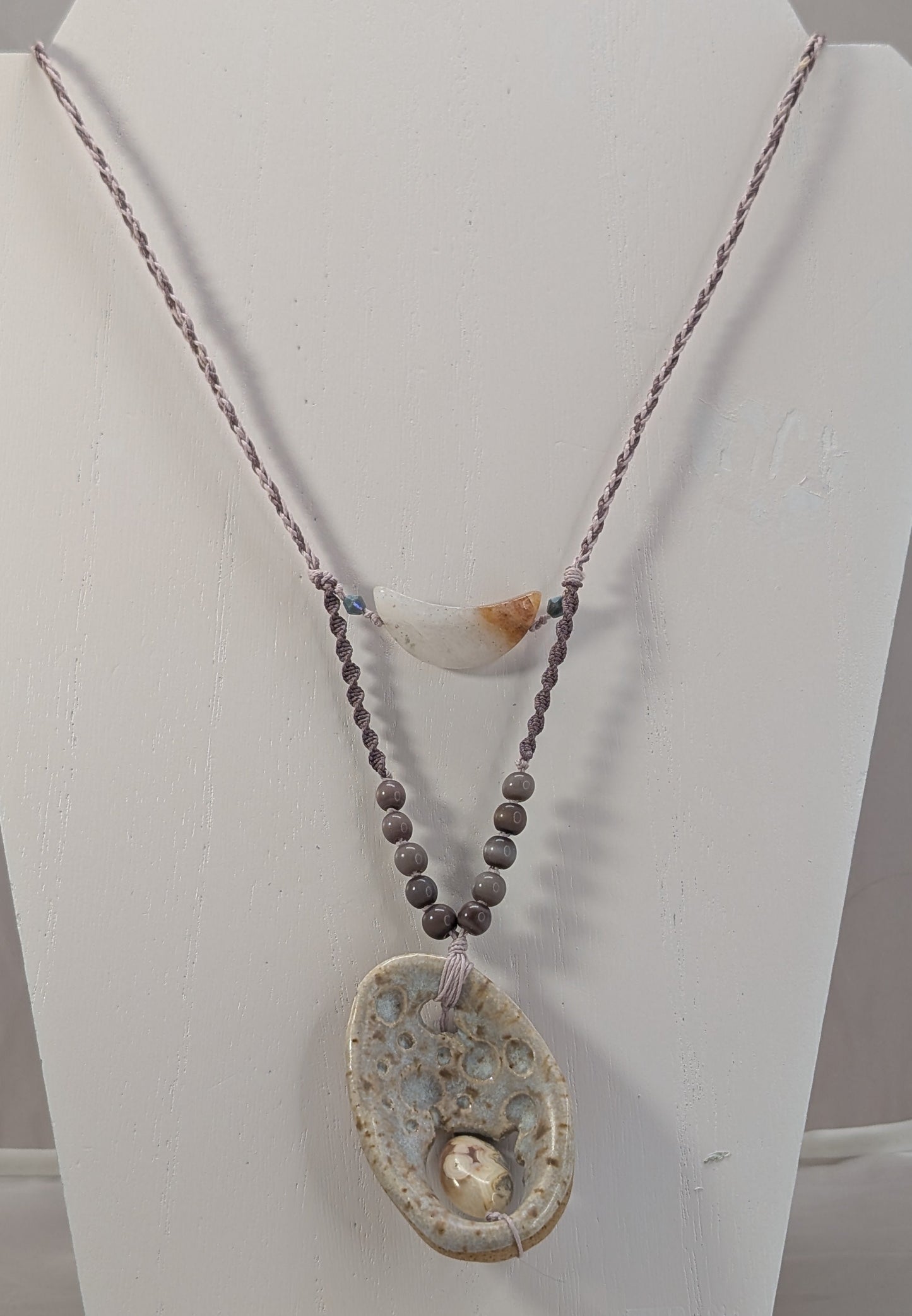 Necklace with a large pendant on a white stand