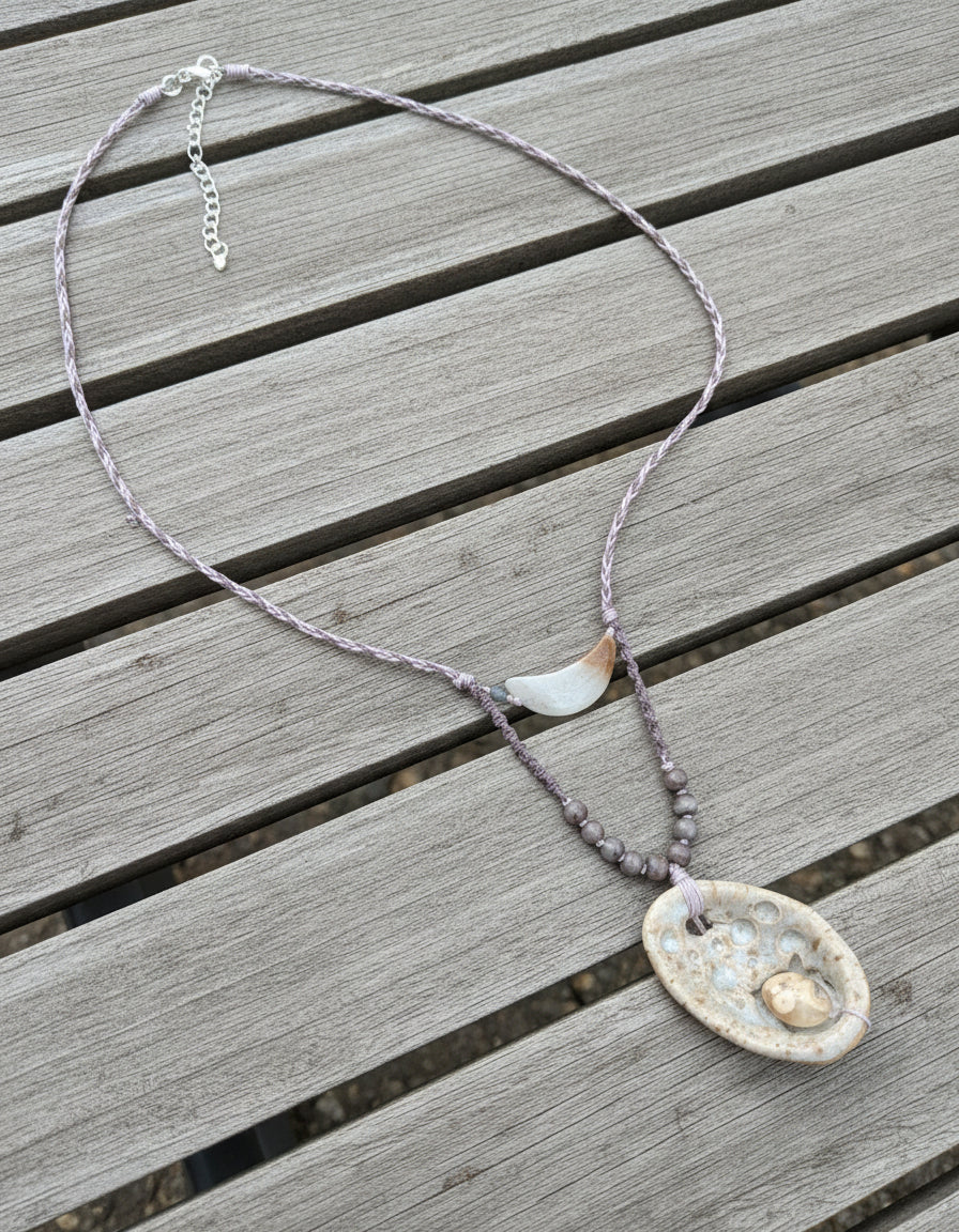 Necklace with a decorative pendant on a light gray background