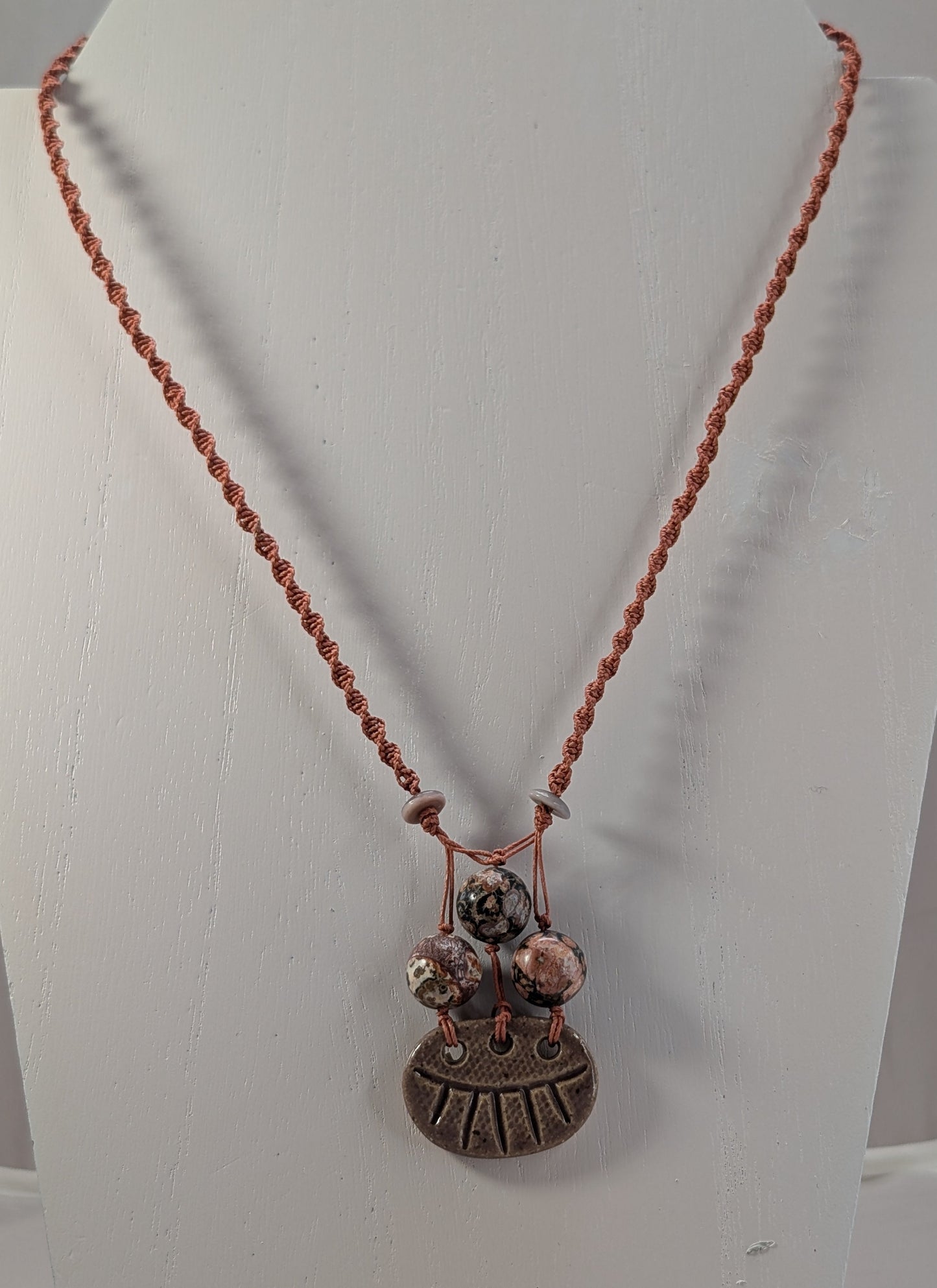 Necklace with a pendant on a mannequin bust against a white background