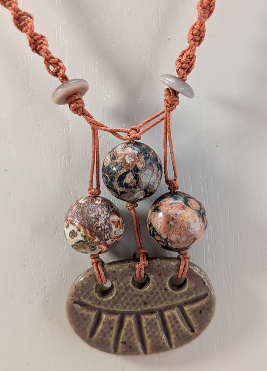 Necklace with ceramic beads and a large pendant on a white background