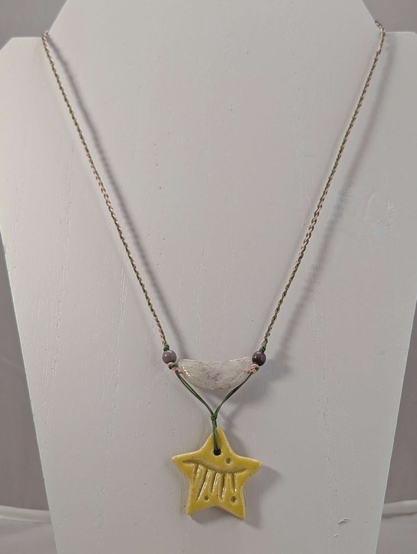 Necklace with a yellow star pendant on a white stand
