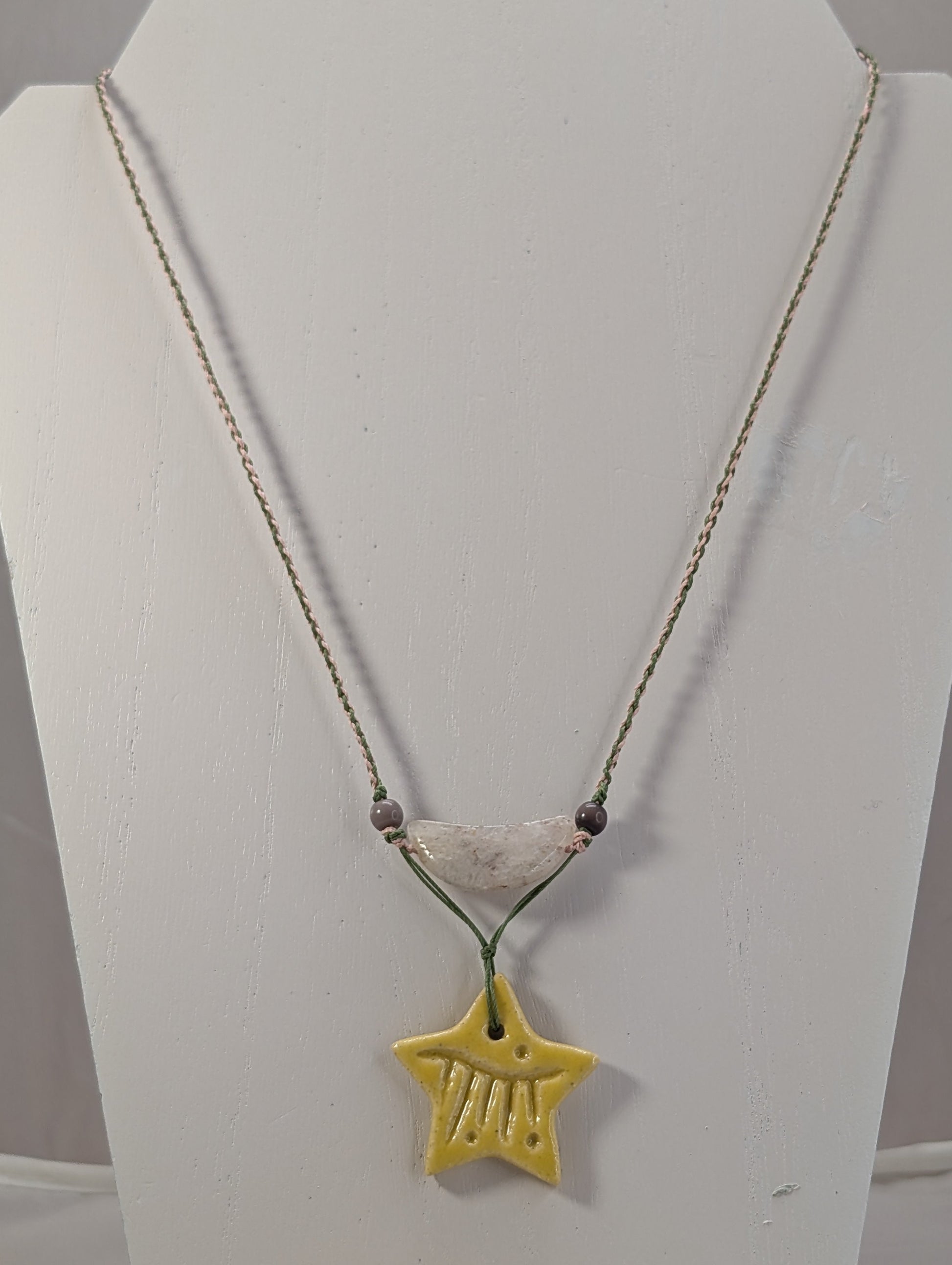 Necklace with a yellow star pendant on a white stand