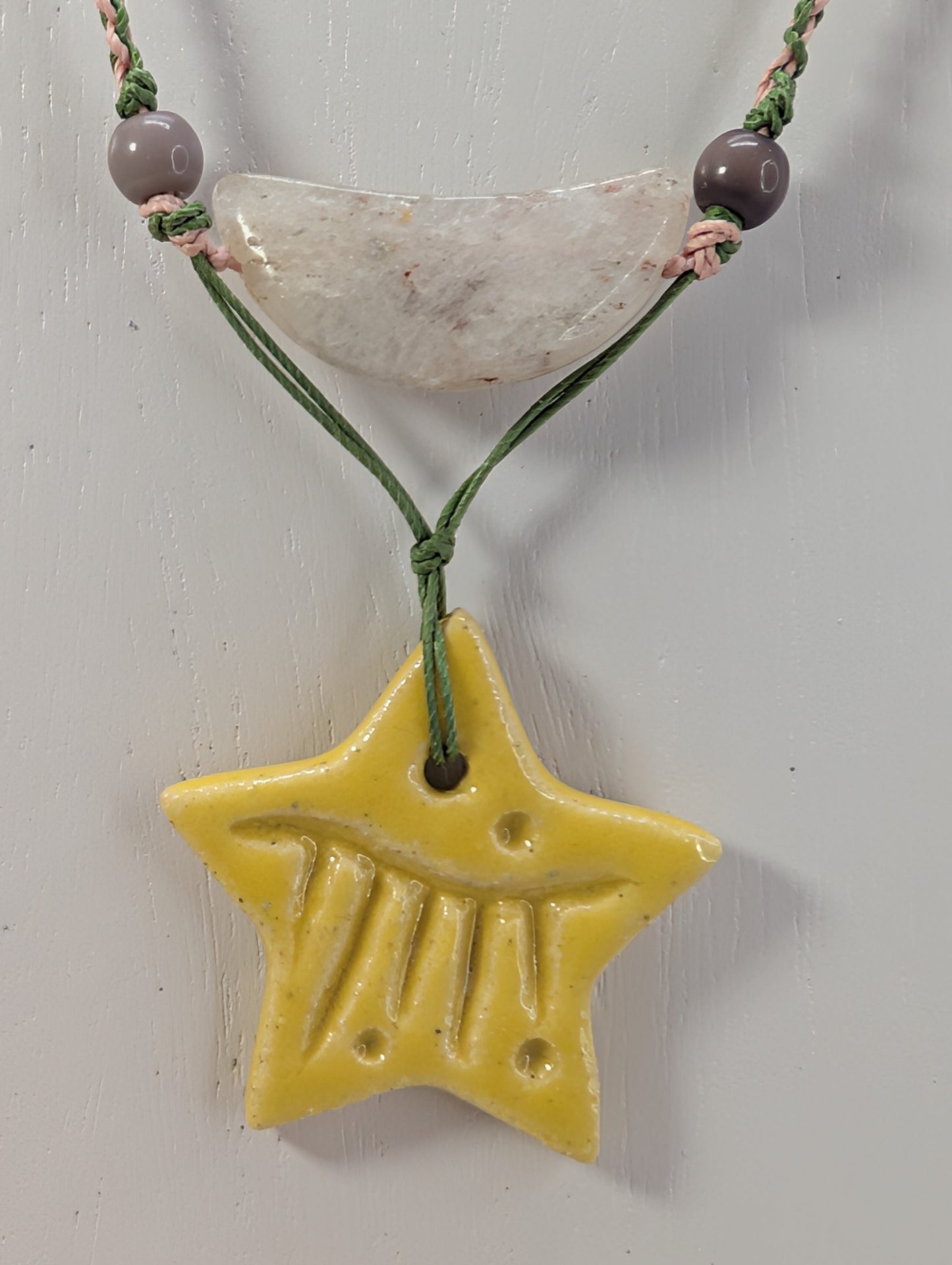 Necklace with a yellow star pendant and beads on a white background