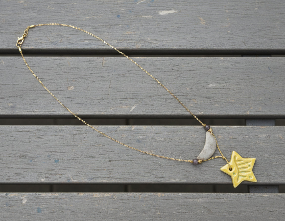Knotted string necklace with a gold star pendant on a gray background