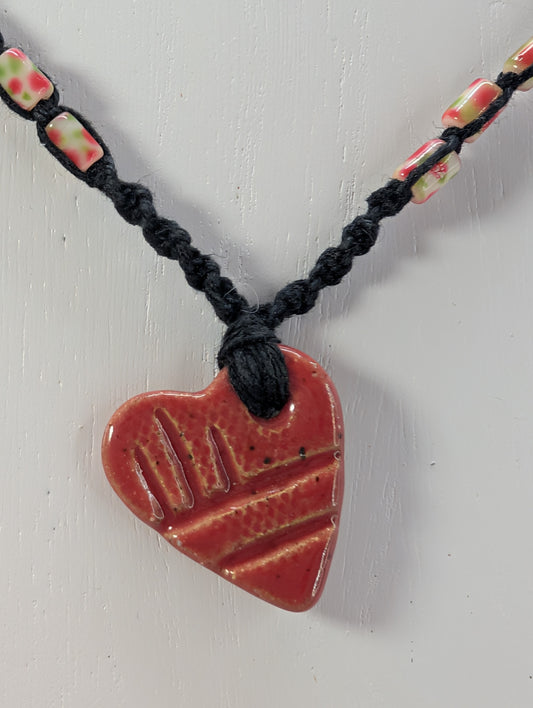 Necklace with a red heart-shaped pendant on a white background