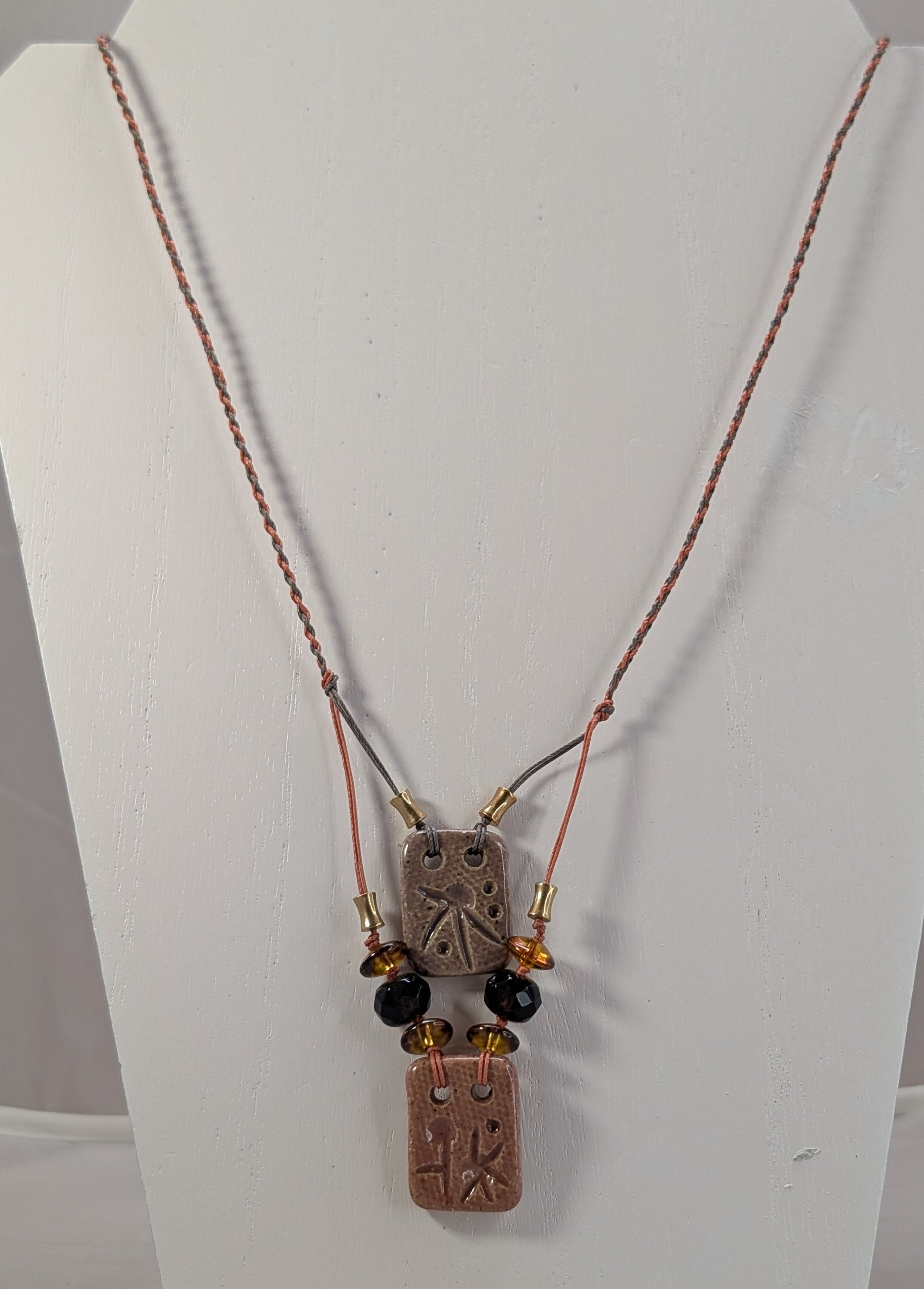 Necklace with pendant on a mannequin bust against a white background