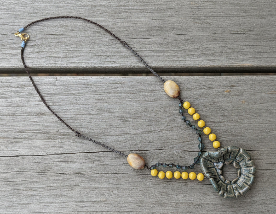 Necklace with beads and decorative element on a gray background