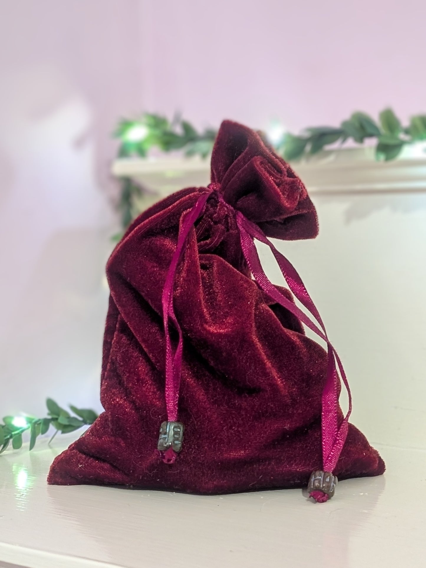 Red velvet drawstring bag on a white surface 